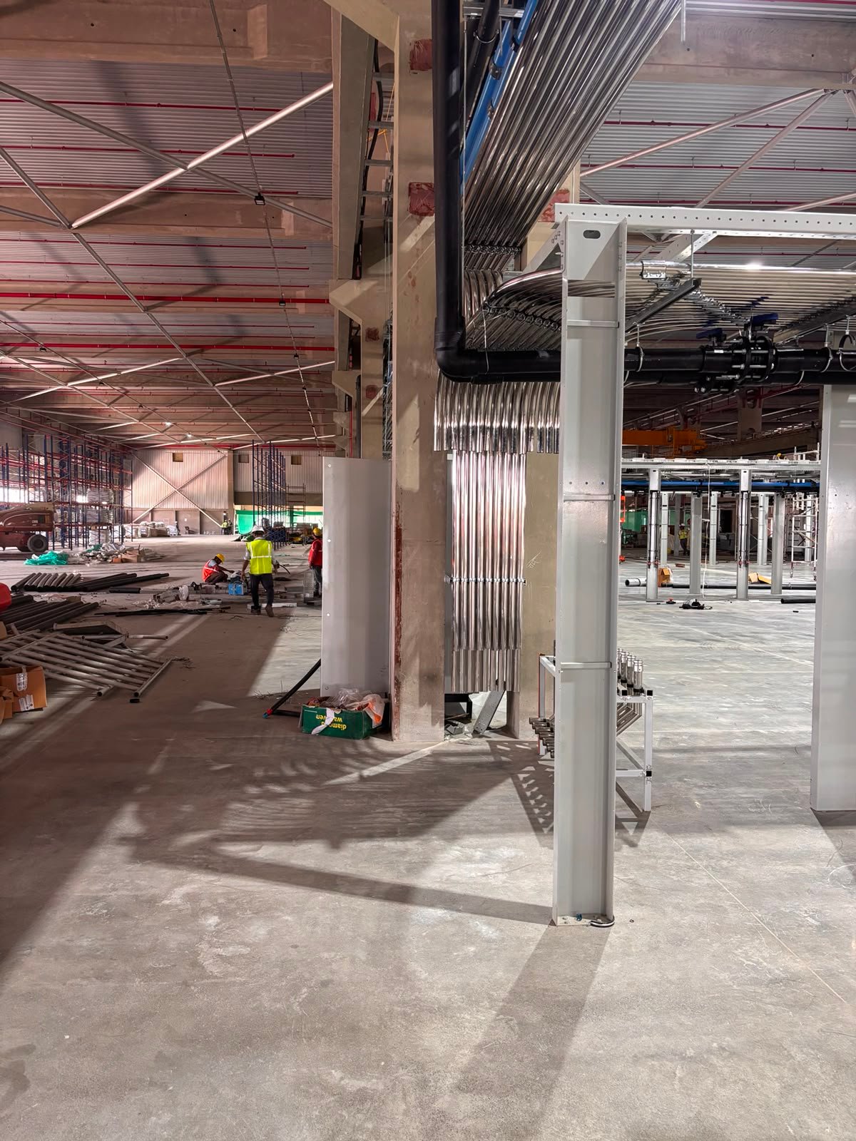 Stainless process pipes and structural supports being installed inside an industrial facility